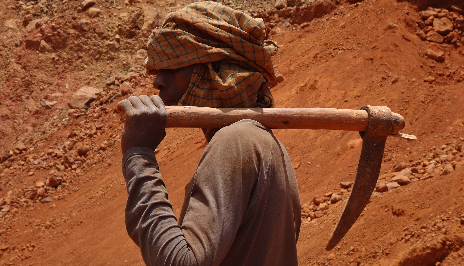 Artisanal miner in Africa holding a digging tool